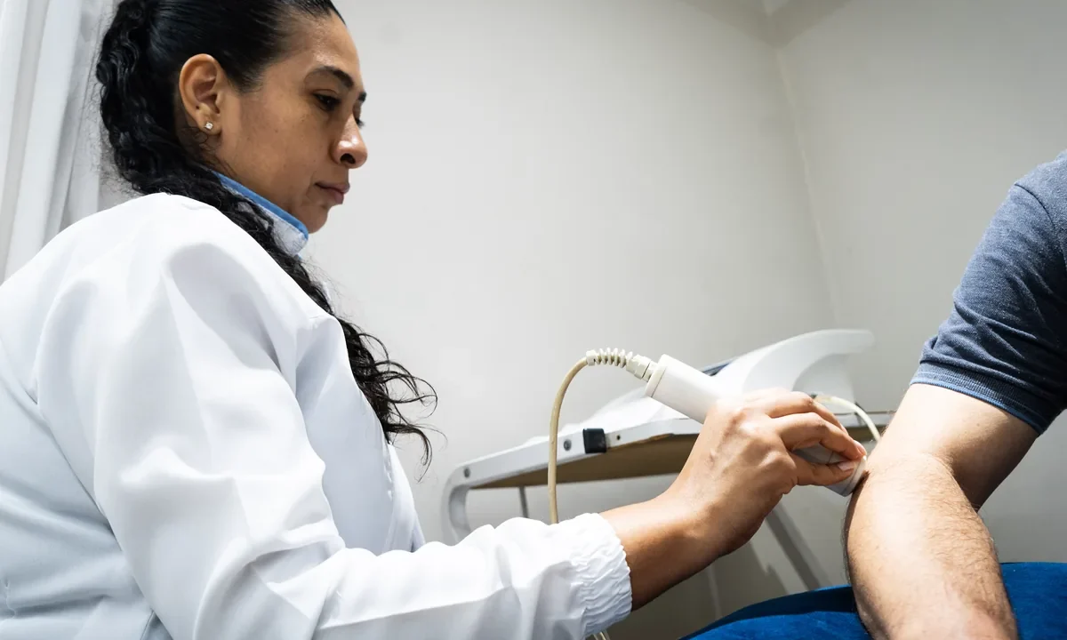 Fisioterapeuta da Center Trauma aplica ultrassom terapêutico no braço de um paciente