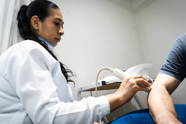 Fisioterapeuta da Center Trauma aplica ultrassom terapêutico no braço de um paciente
