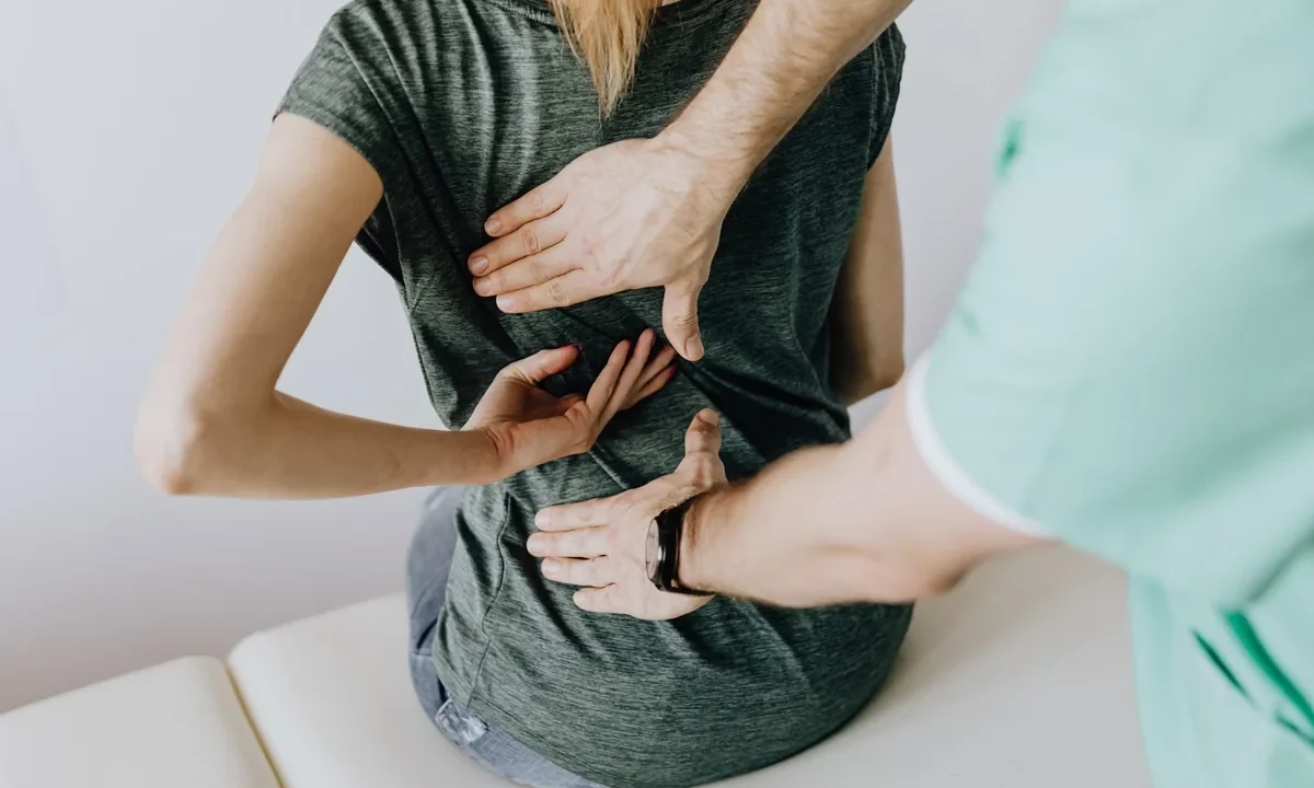 Terapeuta aplica técnica manual de osteopatia na região lombar