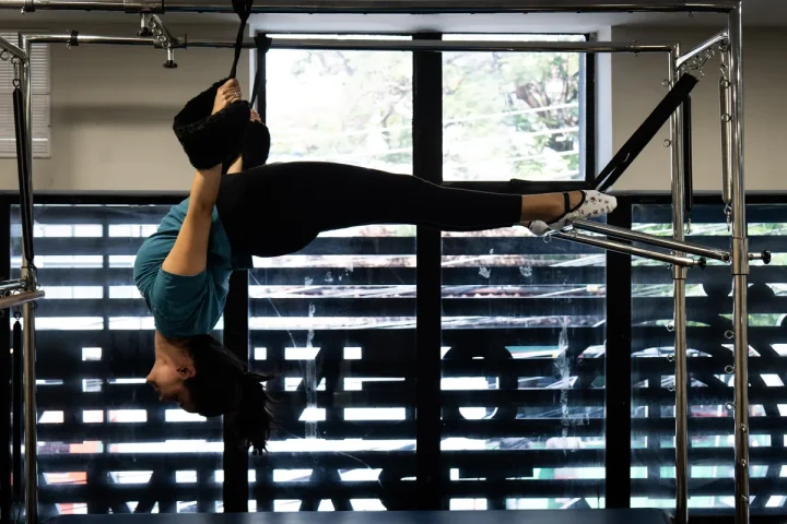 Aluna em exercício no aparelho de Pilates da Center Trauma