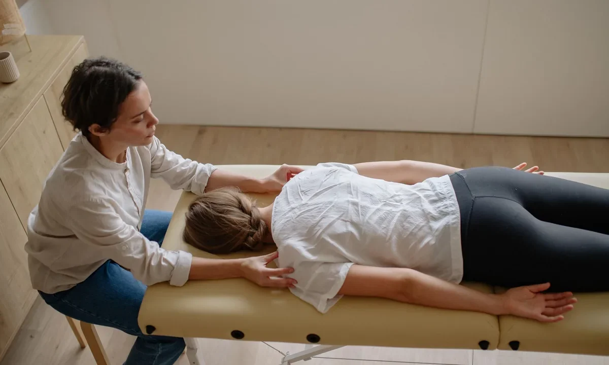 Terapeuta realiza técnica manual de quiropraxia na coluna de uma paciente