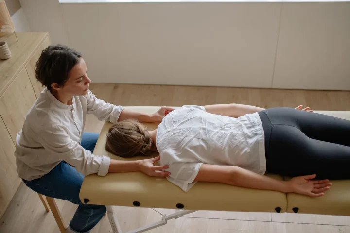 Terapeuta realiza técnica manual de quiropraxia na coluna de uma paciente